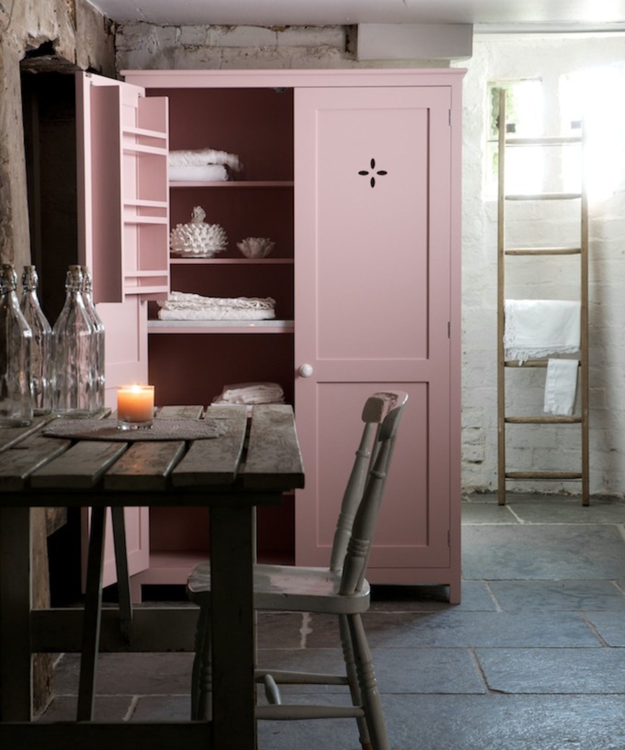 A pink pantry cupboard with cabinet cutouts