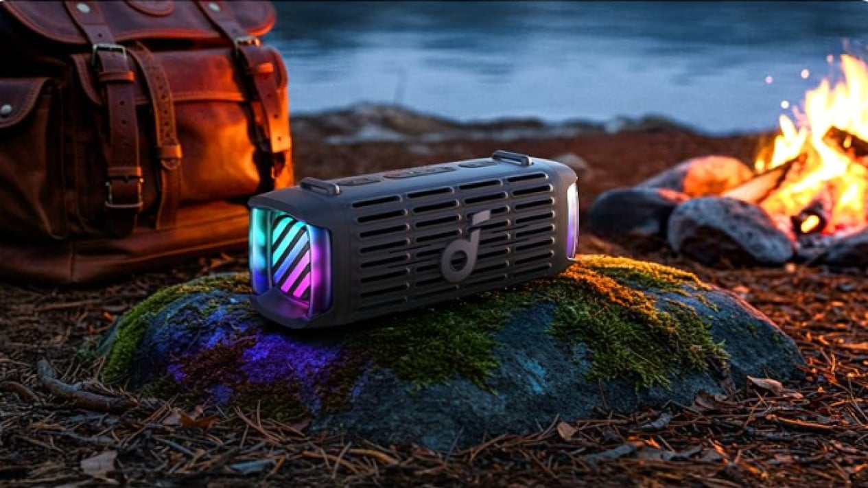 A lifestyle image showing the Soundcore Boom 3i's lighting system. It's next to a satchel and a small fire as the daylight fades