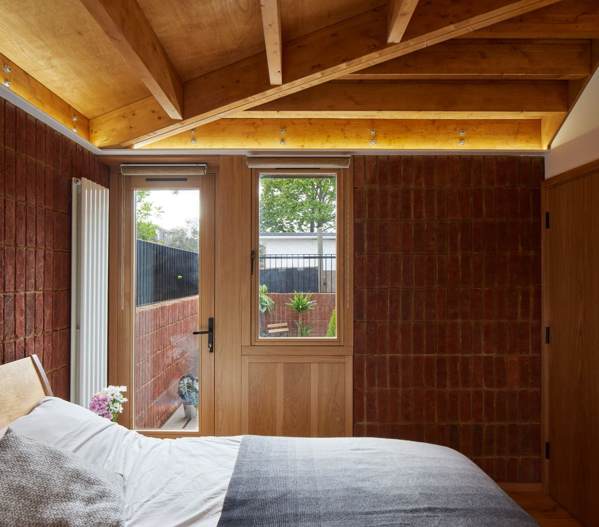 A bedroom with an exposed brick wall and double bed