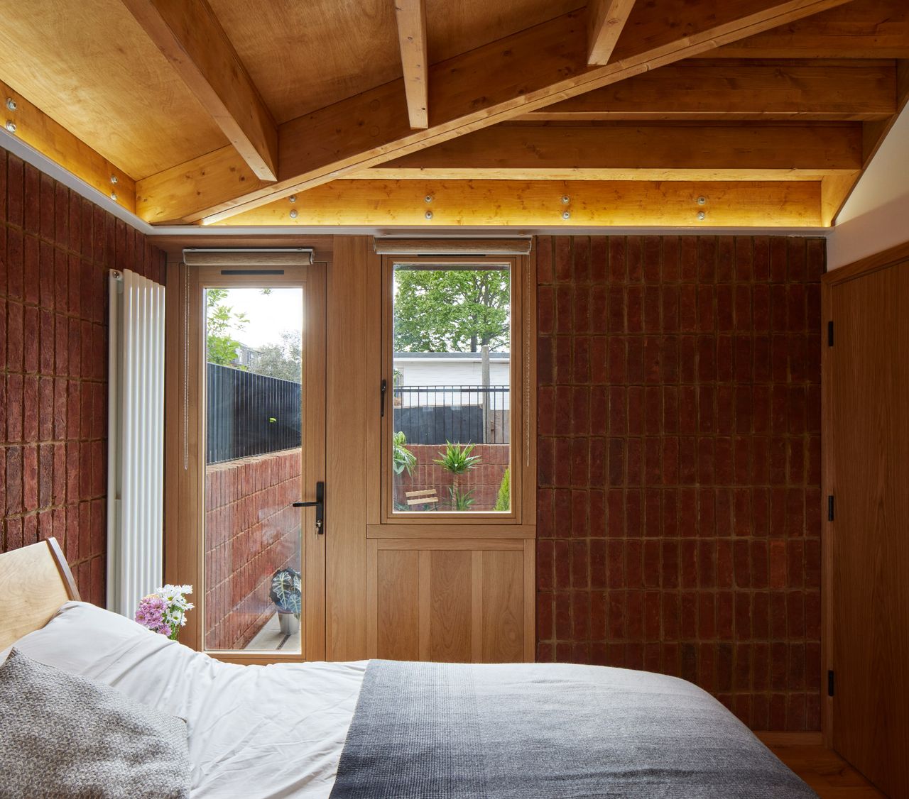 A bedroom with an exposed brick wall and double bed