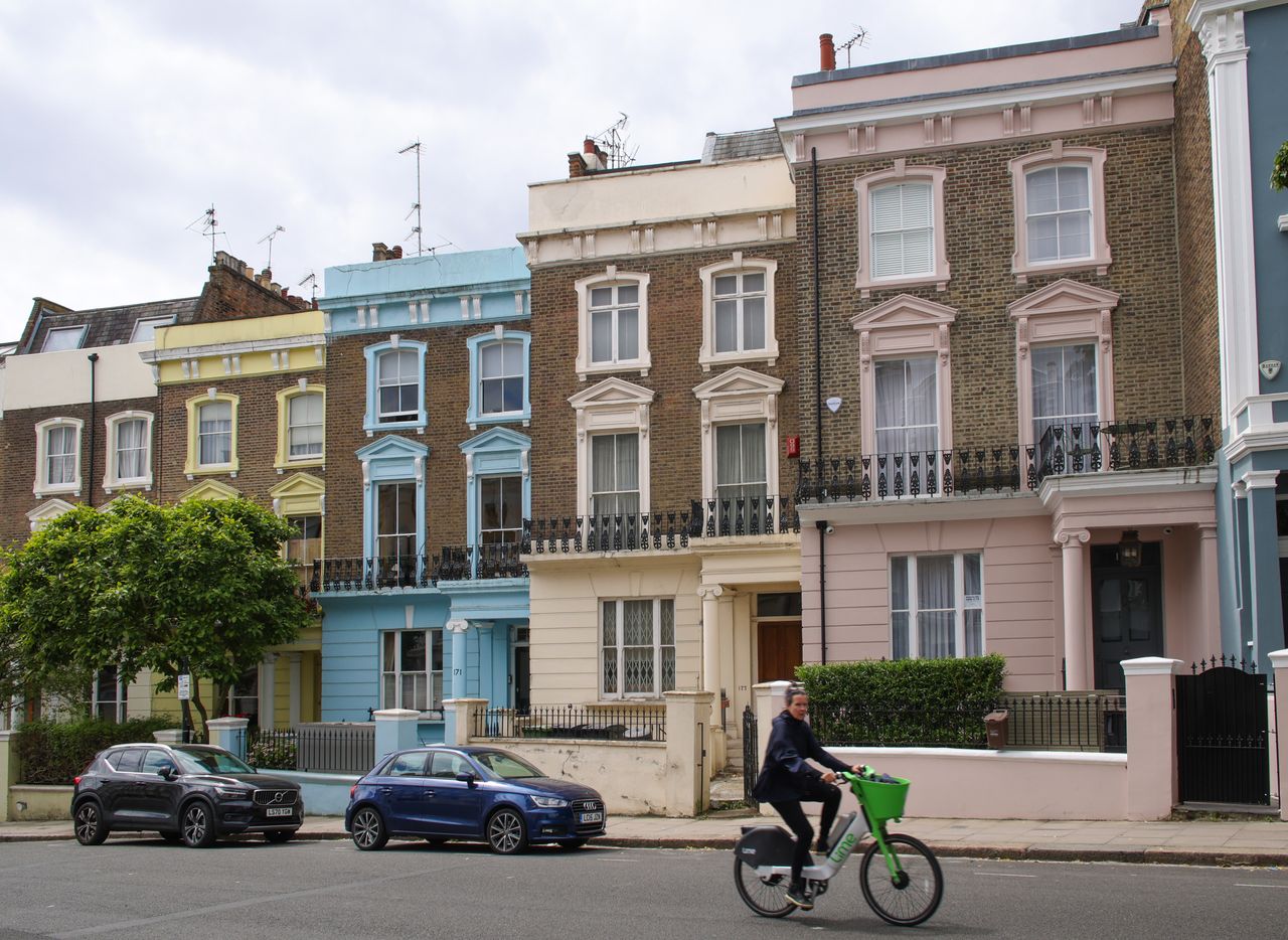 Image of a woman cycling past colorful houses on Primrose Hill, taken on the Sigma 18-50mm f/2.8 DC DN | C Canon RF