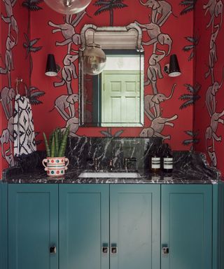 bathroom with red elephant wallpaper and green cabinets