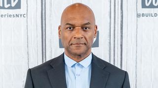 Colin Salmon at a press event wearing a suit and tie