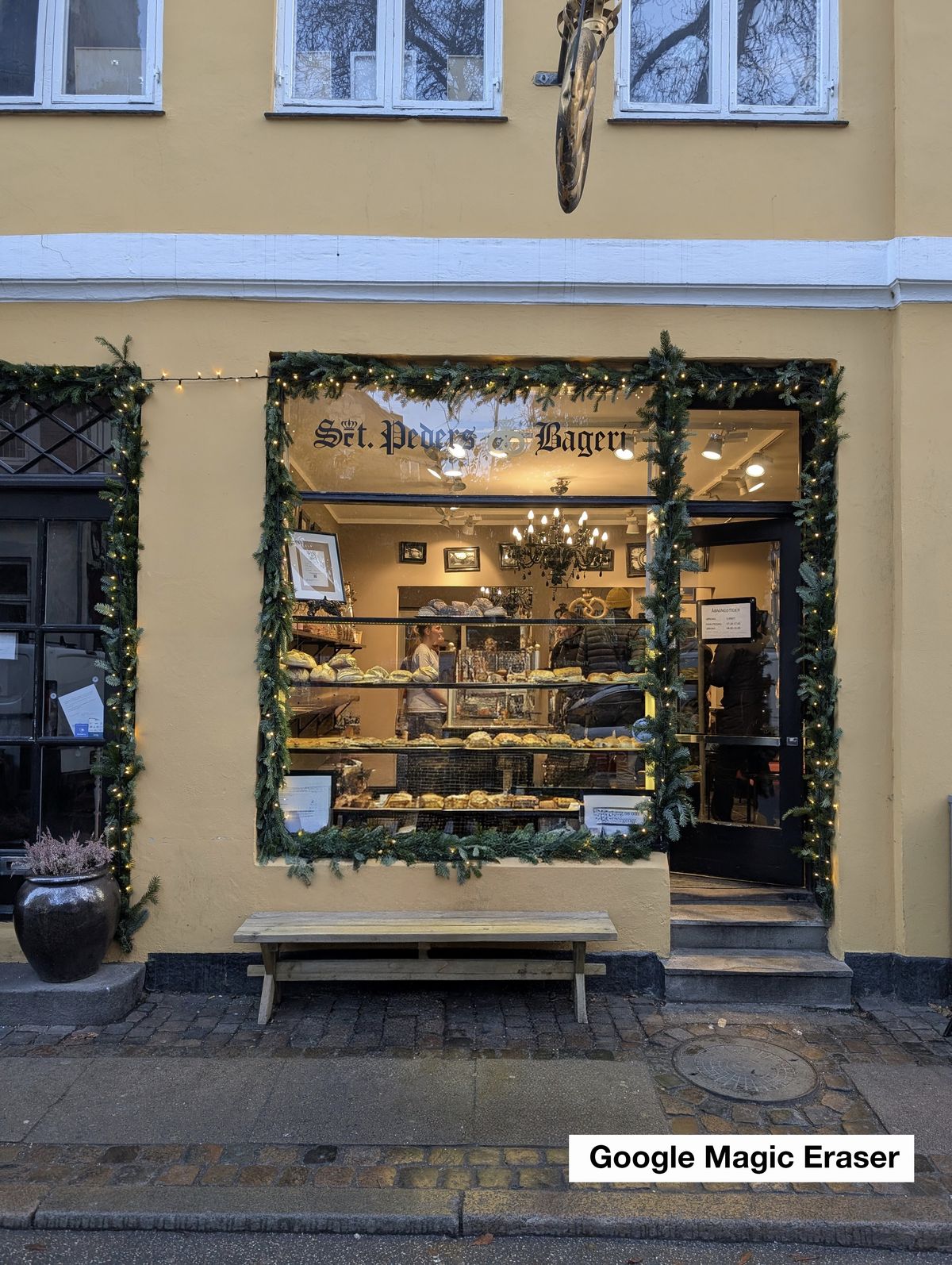 Two people outside a bakery window decorated for christmas