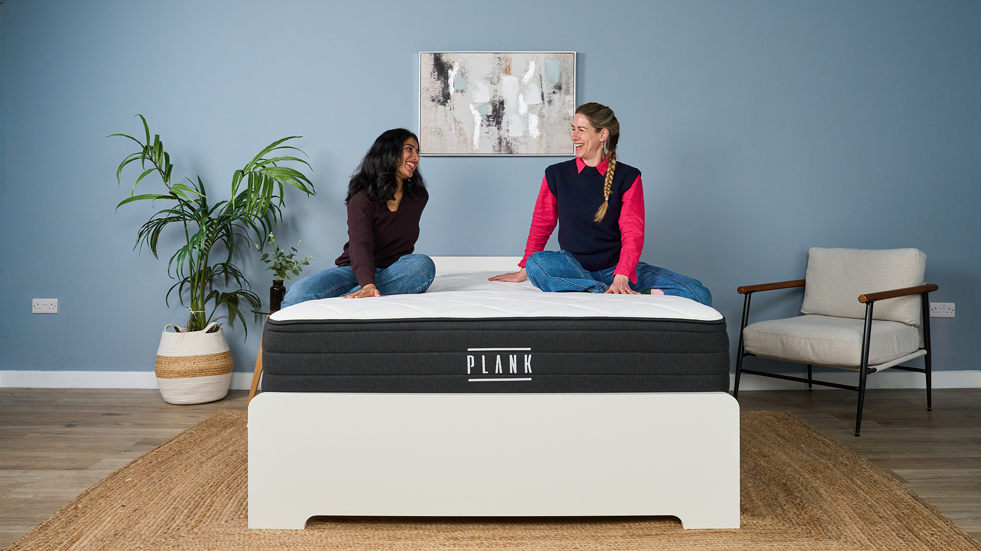 Mattress testers Becky George (left) and Nicola Appleton (right) sit on the Plank Firm Luxe mattress in our sleep studio.