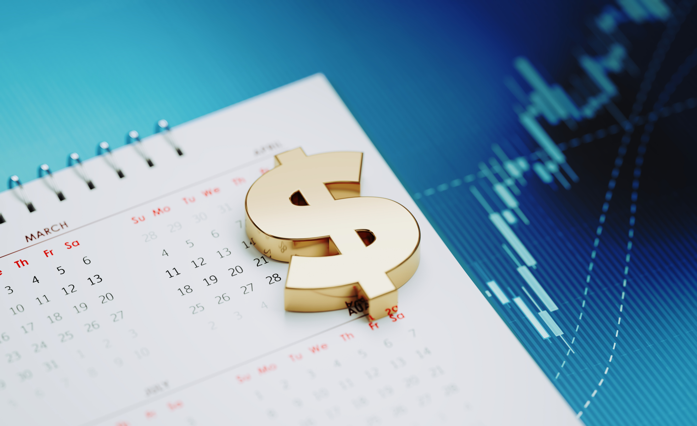 Gold colored American dollar sign sitting over a white calendar on blue financial graph