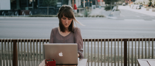 Woman sat alone outside with laptop