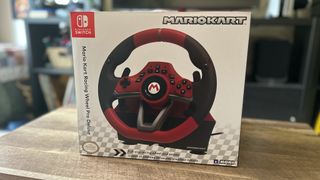 Hori Mario Kart Racing Wheel Pro Deluxe in box on a wooden table