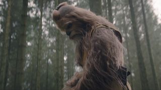 Kelnacca se tient seule dans une forêt et regarde quelque chose dans Star Wars : The Acolyte.