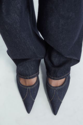 Sepatu hak anak kucing dengan model slingback runcing dari bahan denim