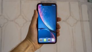 An iPhone XR in from the front, in someone's hand