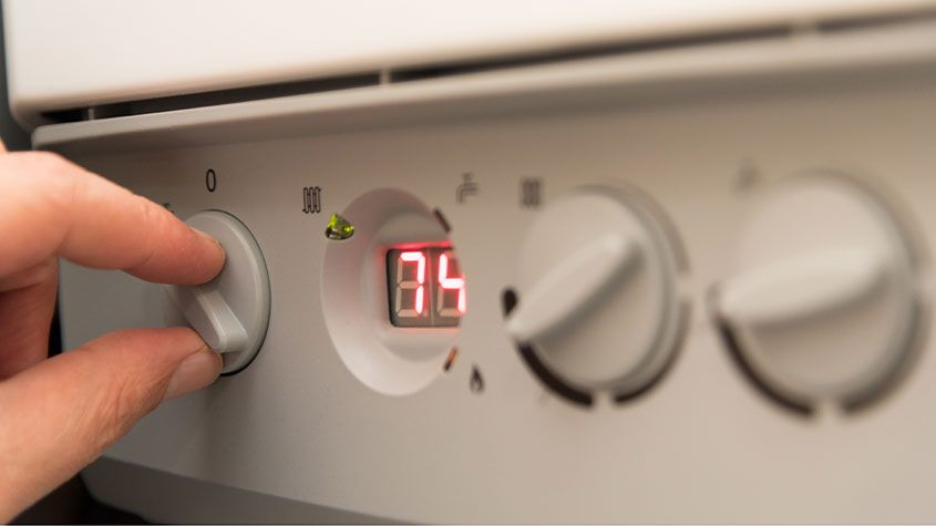 A hand adjusting a boiler