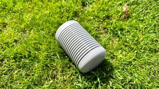 Beosound Explore Bluetooth speaker in the grass on its side