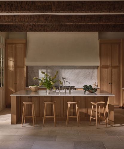 Wooden kitchen with large wooden island, wooden bar stools surrounding