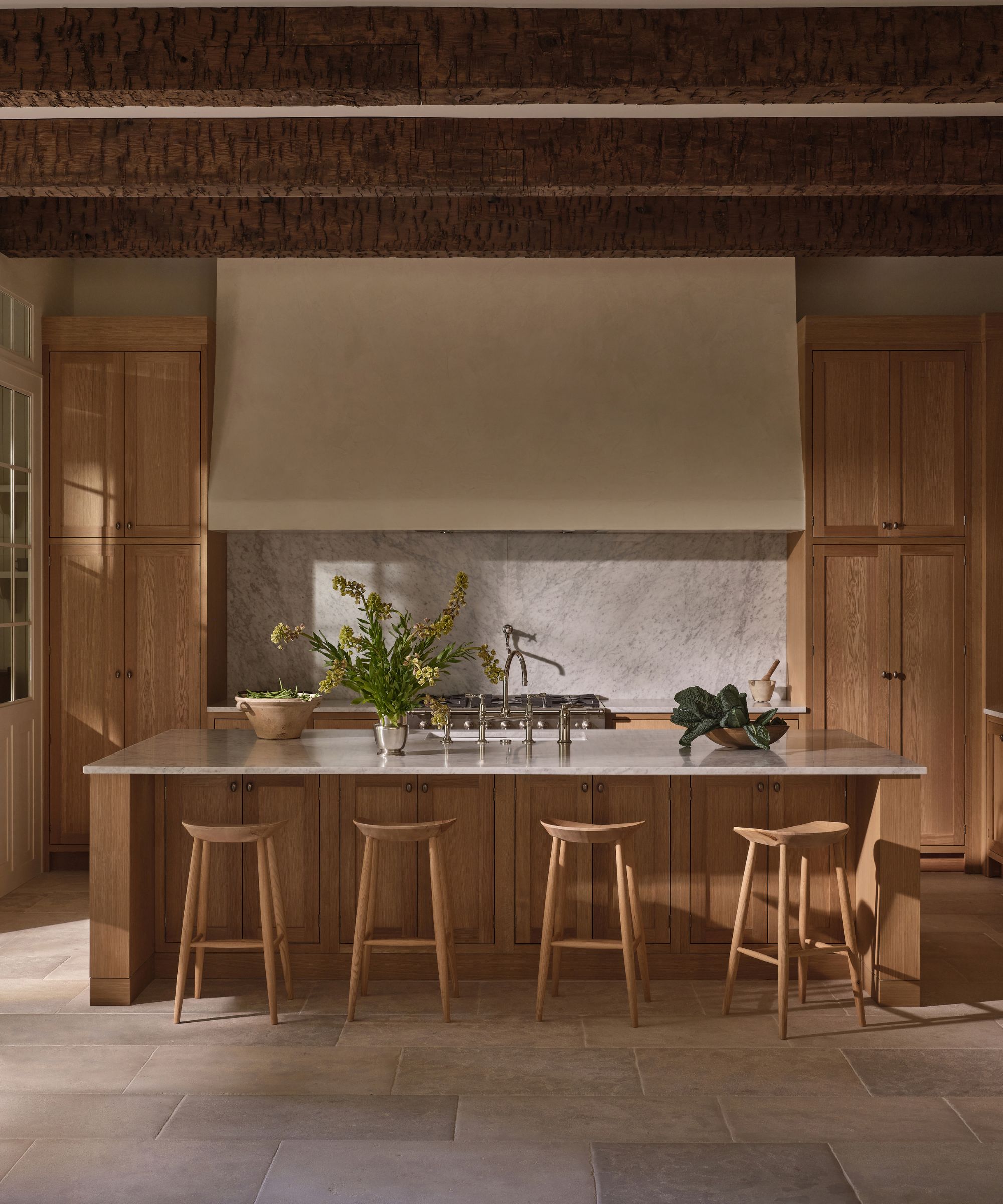 Wooden kitchen with large wooden island, wooden bar stools surrounding