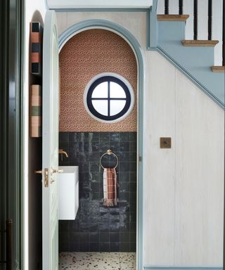 Arched door under the stairs leading to a washroom. Project by Gunter & Co, photograph Mary Wadsworth