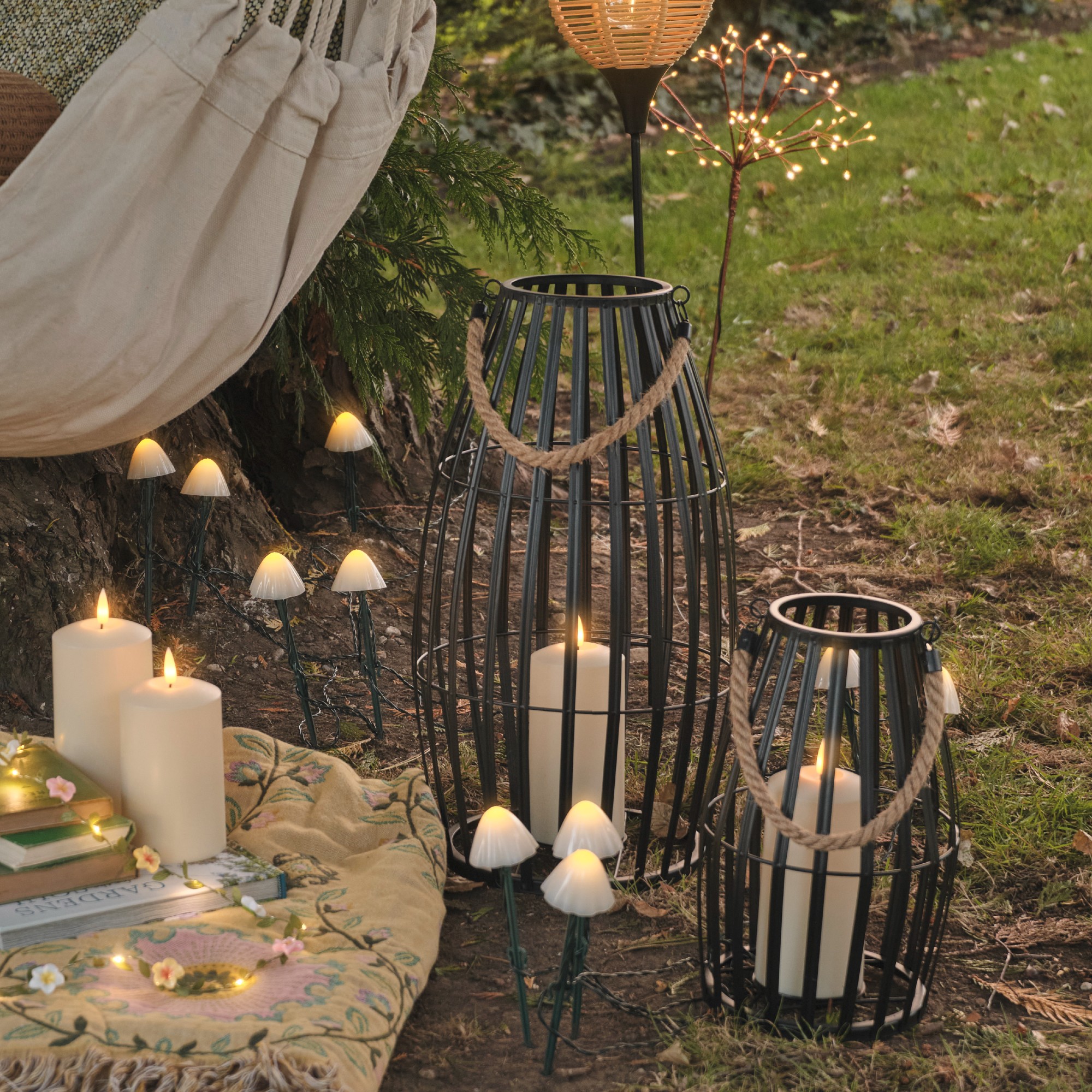 A garden with mushroom stake lights from Lights4fun and lanterns set on the ground