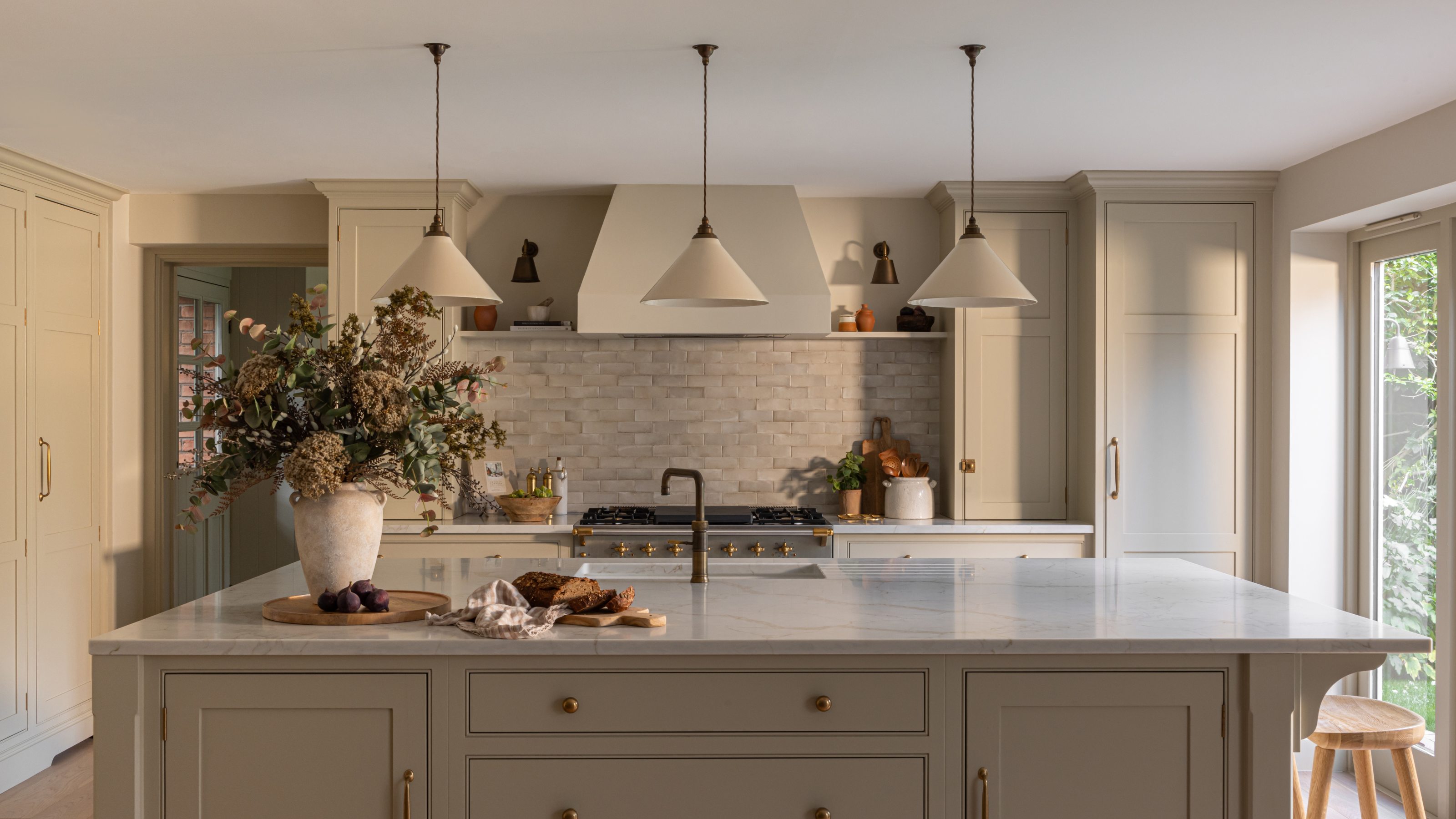 a large kitchen island in an off-white room with flowers on the counters