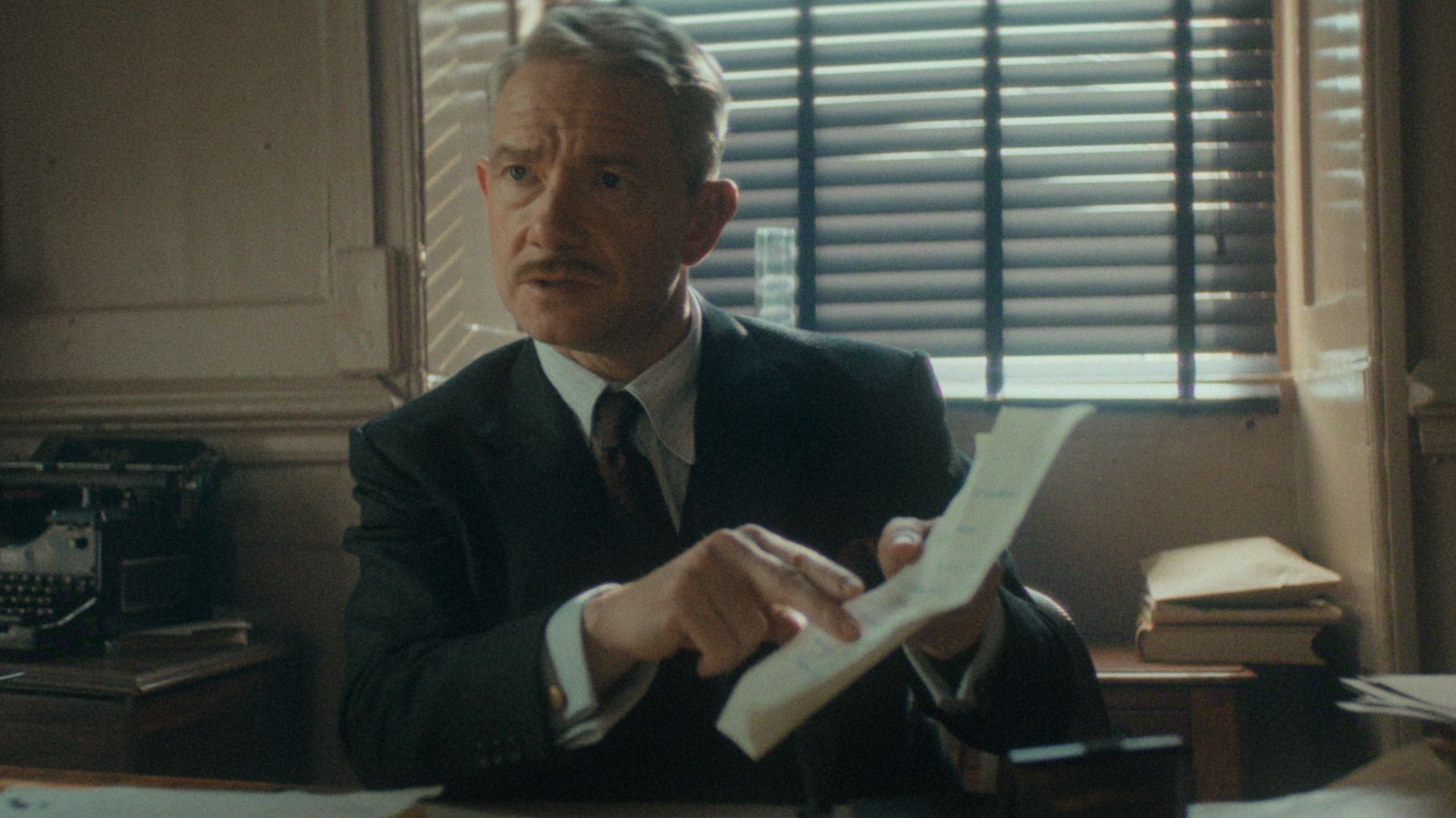 Martin Freeman points to a piece of paper he's holding