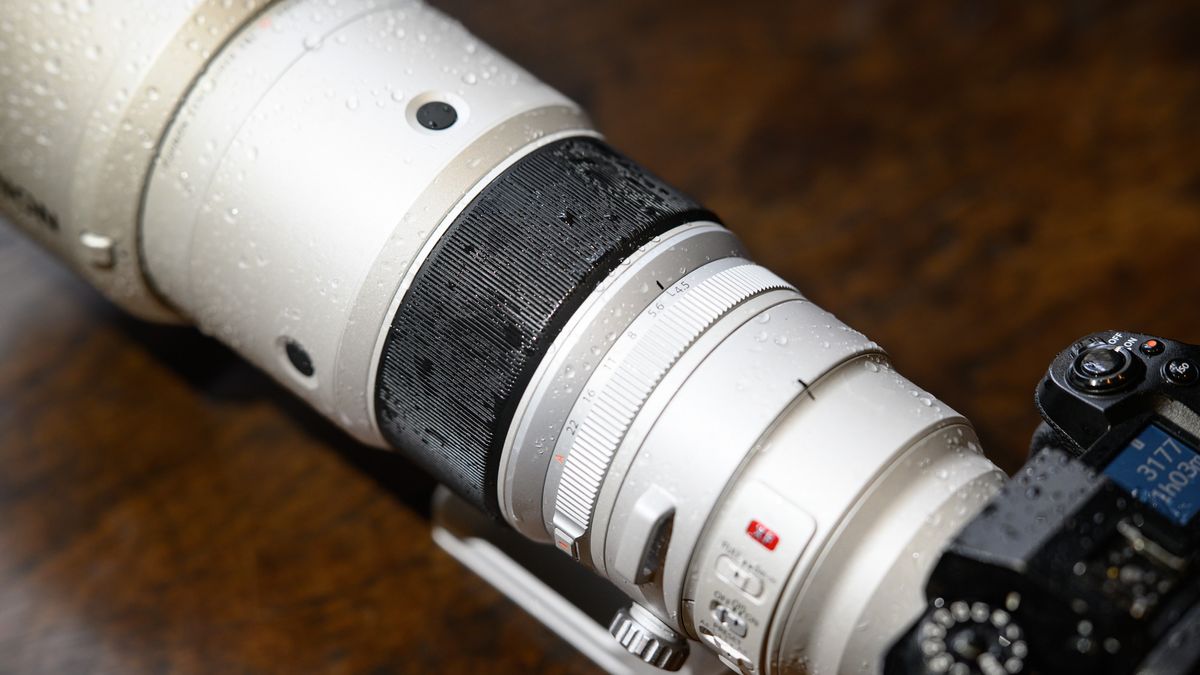 The Fujifilm XF 400mm F4.5 R LM OIS WR telephoto prime lens attached to a Fujifilm X-H2S camera, on a wooden table