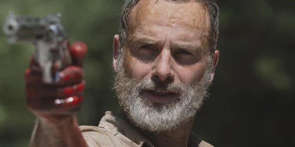 Andrew Licoln as Rick Grimes holding a gun in his last Walking Dead episode