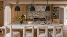 A wood and stone kitchen with an asymmetrical layout and a large island