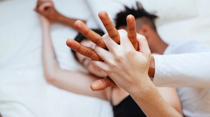 Couple lying in bed together, holding hands