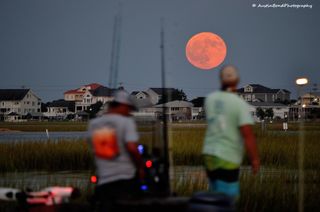 A bright orange Harvest Moon rises over Murrell's Inlet in South Carolina.