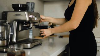 woman using coffee machine at home