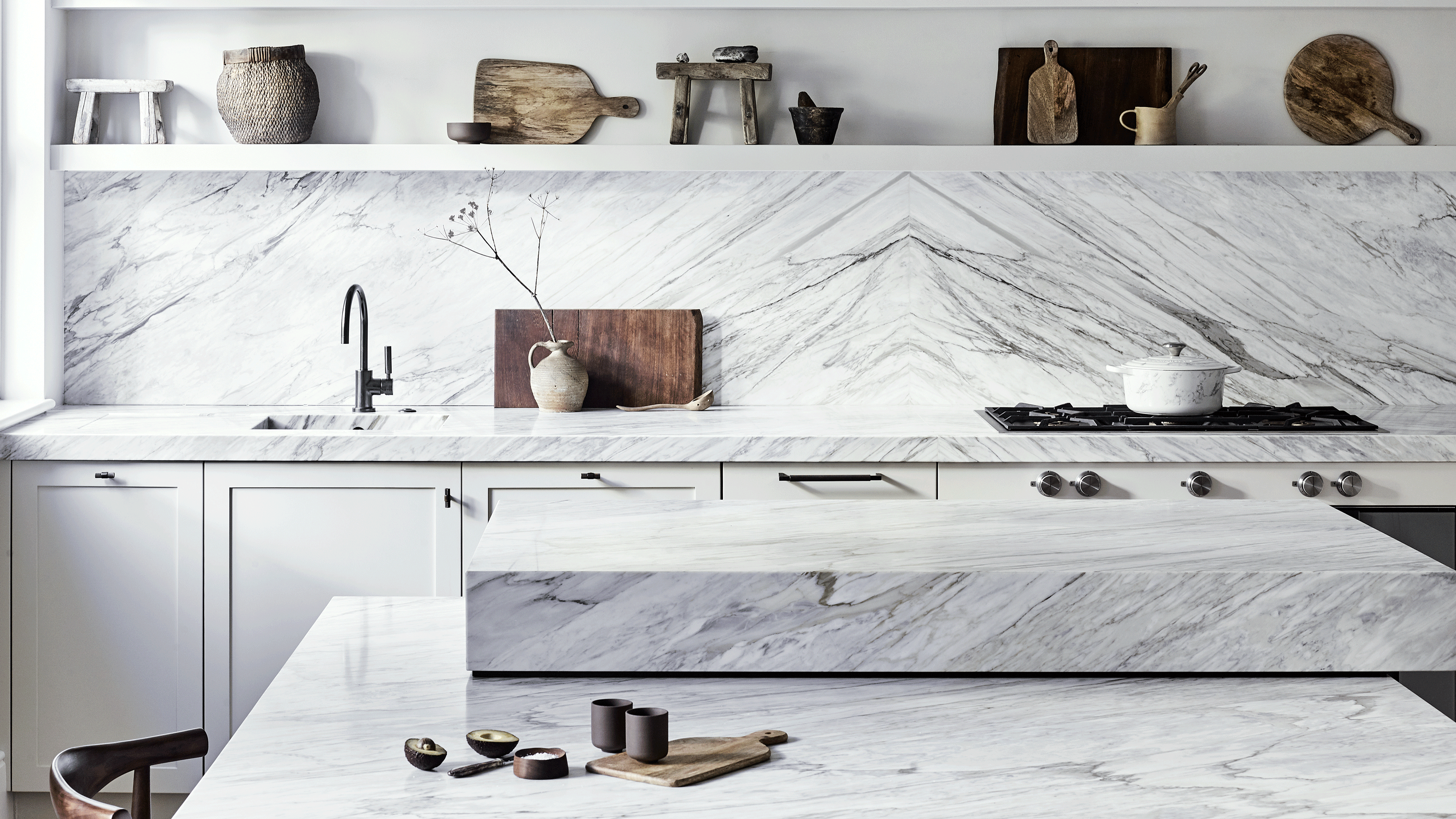 White marble kitchen with striking veining on the worktop and splashback