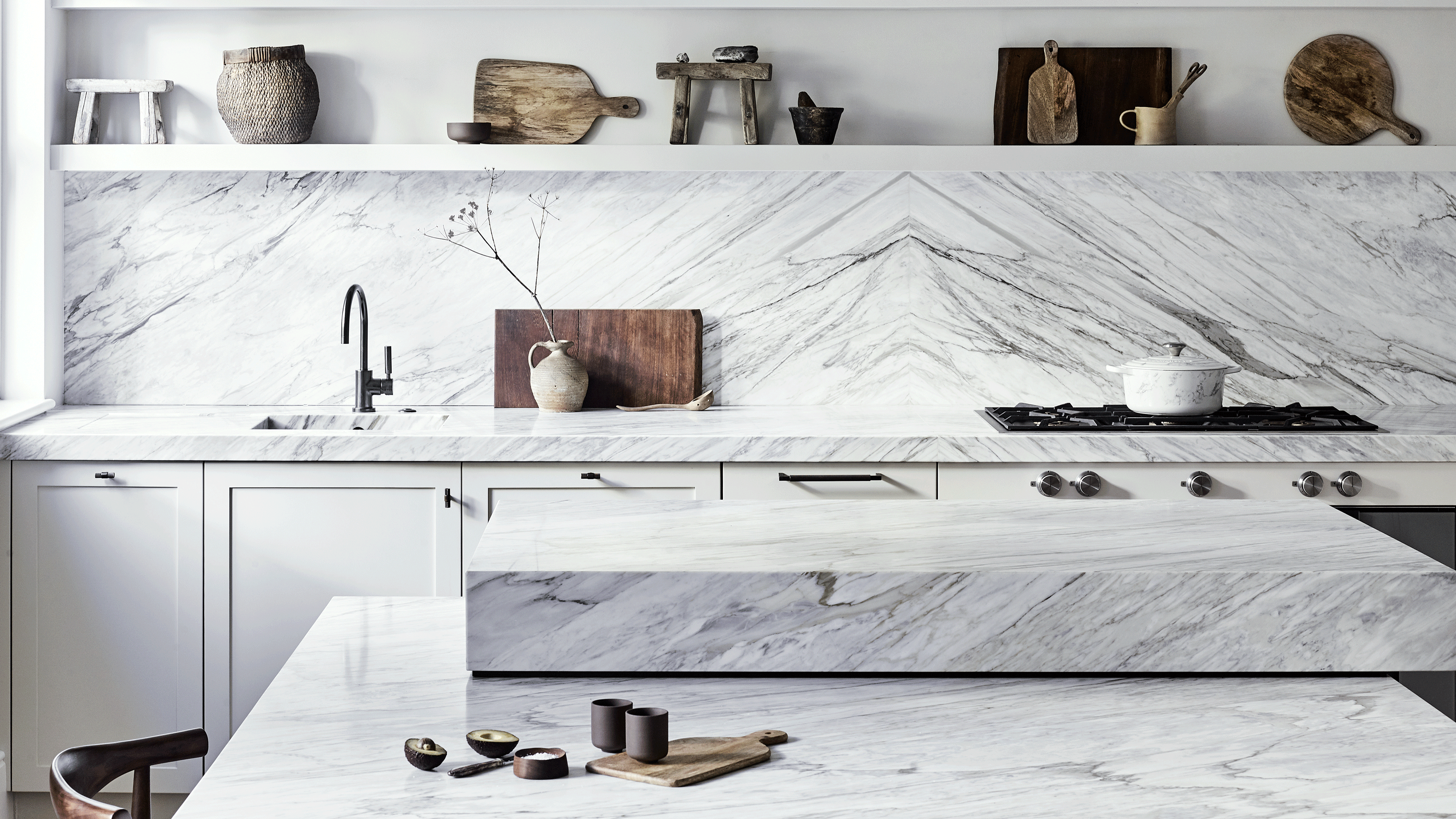 Remodelling a kitchen White marble kitchen with striking veining on the worktop and splashback