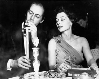 Rex Harrison in a smoking jacket at a dinner with actress Lilli Palmer (Alamy)