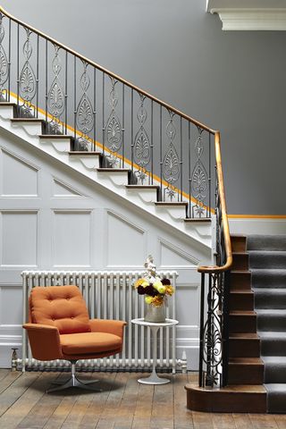 Hallway and staircase with quarter turn and runner with grey wall with orange line above skirting board