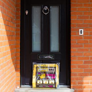 Packaged and folded HIPPO bag outside front door of house