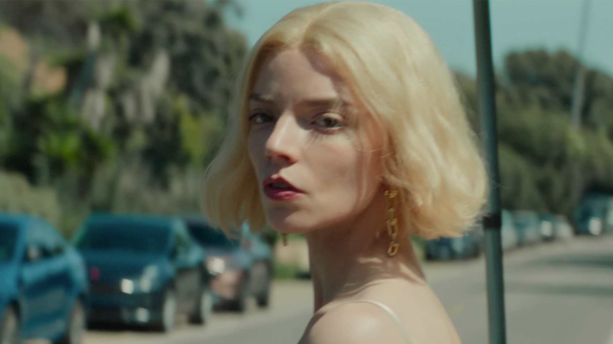 Anya Taylor-Joy with blonde hair looking back to her right, towards the camera in Lucky