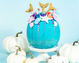 Halloween craft pumpkins decorated with mermaid tails, glitter, and sparkly rhinestones