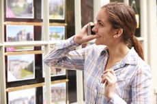 woman looking in estate agent window