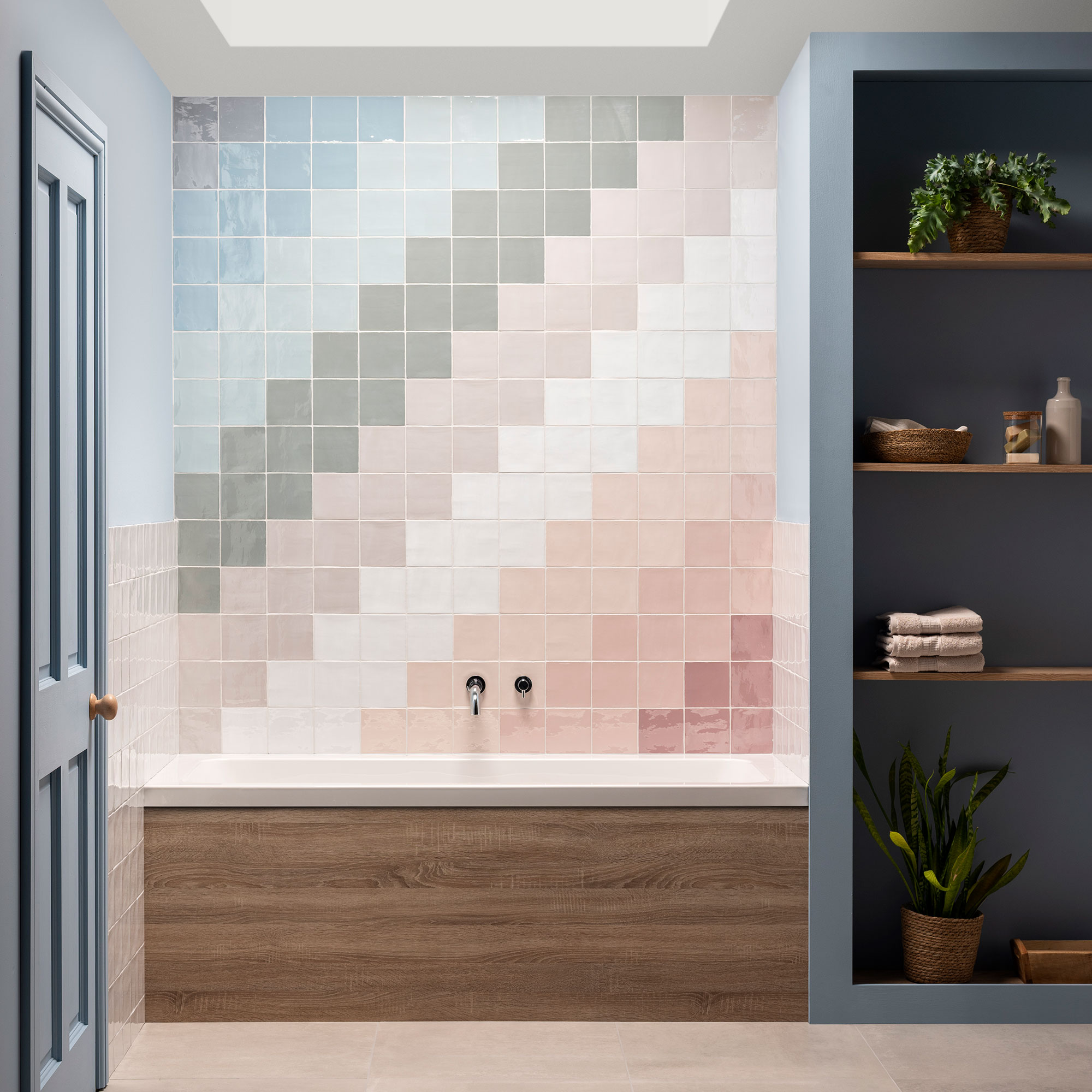 Multicoloured pastel tiles in stripe design above bath