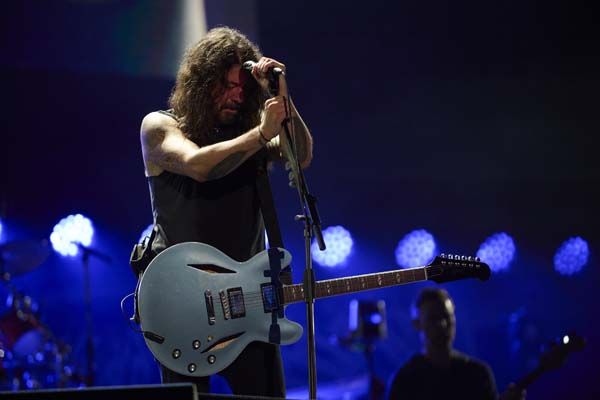 Dave Grohl with his head bowed, onstage