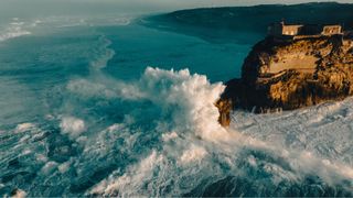 waves crashing against the rocks in Nazare, Portugal