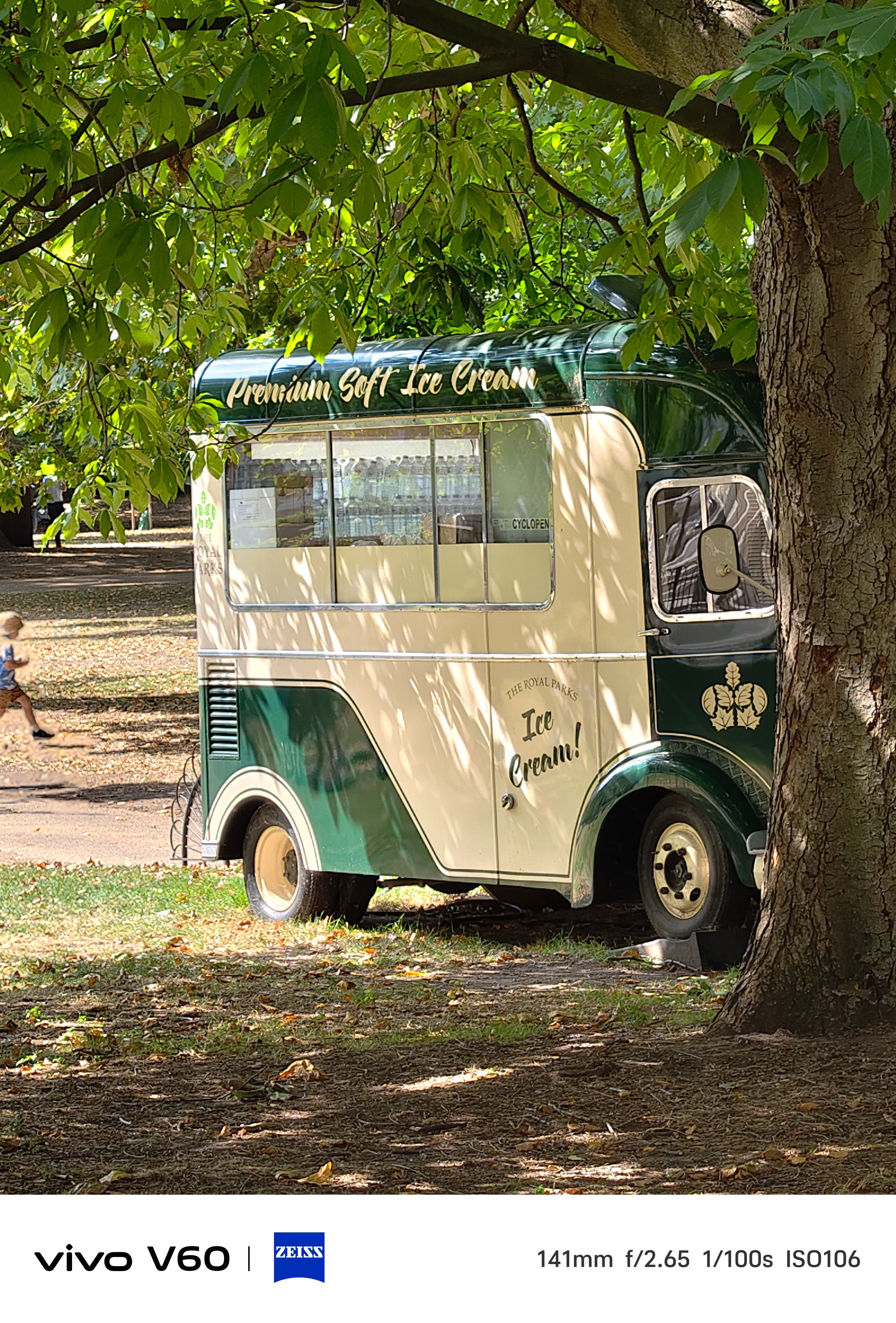 The side of an ice cream truck parked on tree