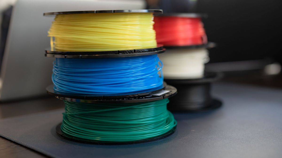 Several rolls of 3D printer filament stacked, each a different colour