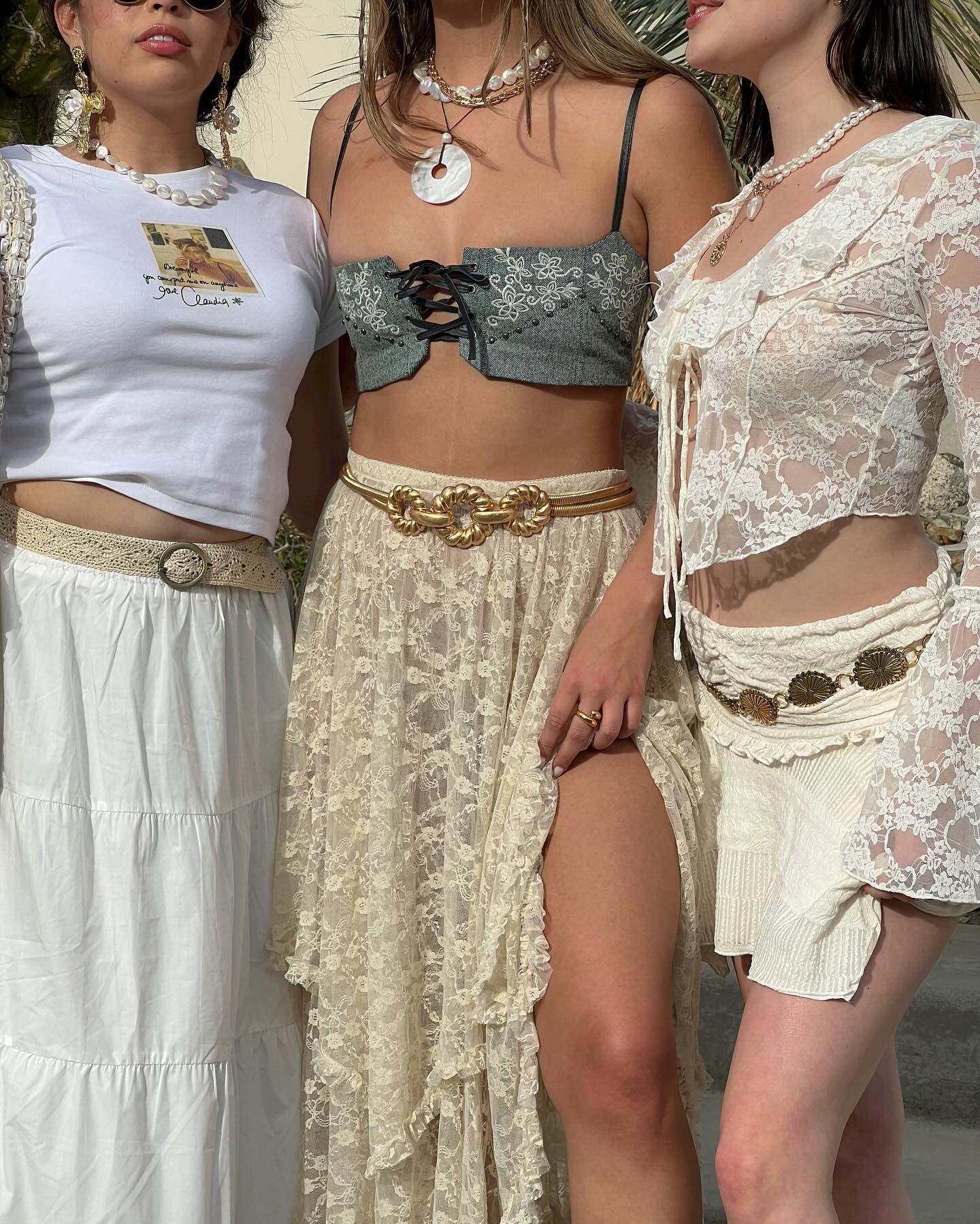 Three women at Coachella wearing white and cream outfits.
