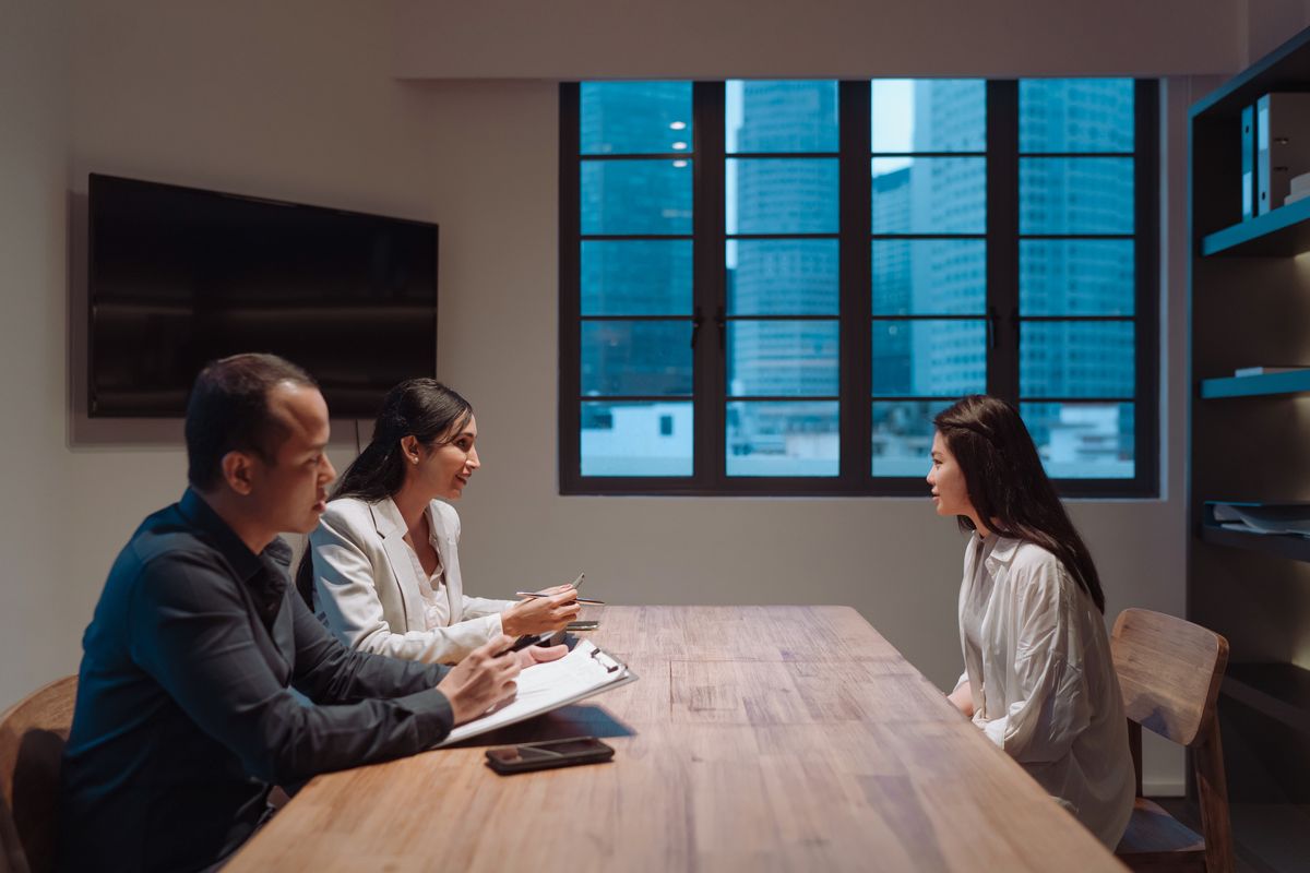 An image of two people interviewing a candidate for a job