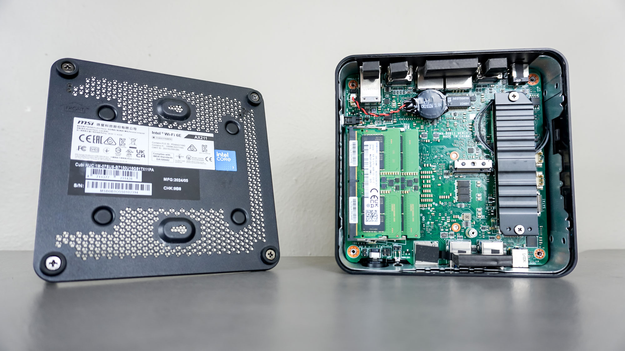 The MSI Cubi NUC 1M mini PC with its case open and motherboard exposed on a desk