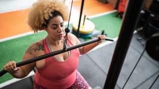 Should you work out twice a day? Image shows woman using machine at gym