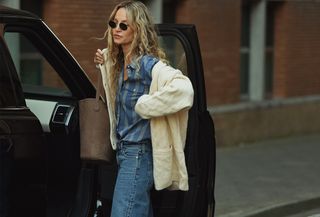 Woman wearing a striped button-down and jeans with a cable-knit cardigan from J.Crew.