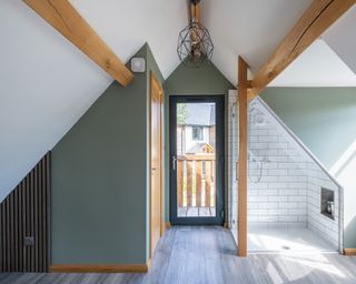 Bedroom above garage with green wall and white tiled shower