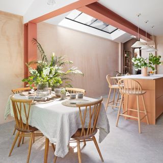 dining area with table and chairs, peach wooden beams and peach island unit