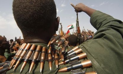 Sudanese military soldiers cheer and hold up their weapons during a visit from Sudanese President Omar al-Bashir in the disputed oil-rich town of Heglig.